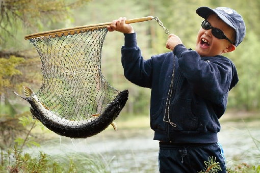 Un jeune pêcheur heureux sur le lac Kermajärvi, à Heinävesi.